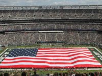 Marines assigned to the 1st Marine Corps District along with members of each branch of service unfurl the American flag during the pregame ceremony at MetLife Stadium, Sept. 8.  Five Marines from 1MCD were on the field representing the Corps during the New York Jets opening day.  Photo By: Cpl. Daniel Valle